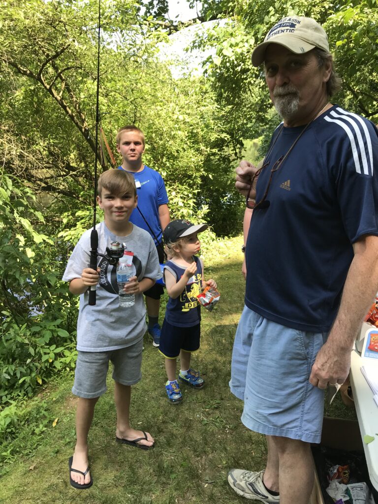 A group of people standing on top of a grass covered field.