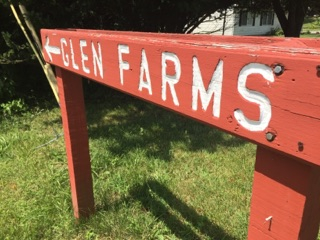 Here's an alt tag for the image: `Glen Farms sign, red wood, arrow left`