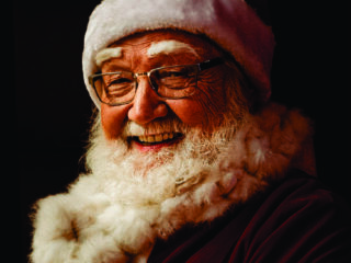 A man dressed as santa claus smiling for the camera.
